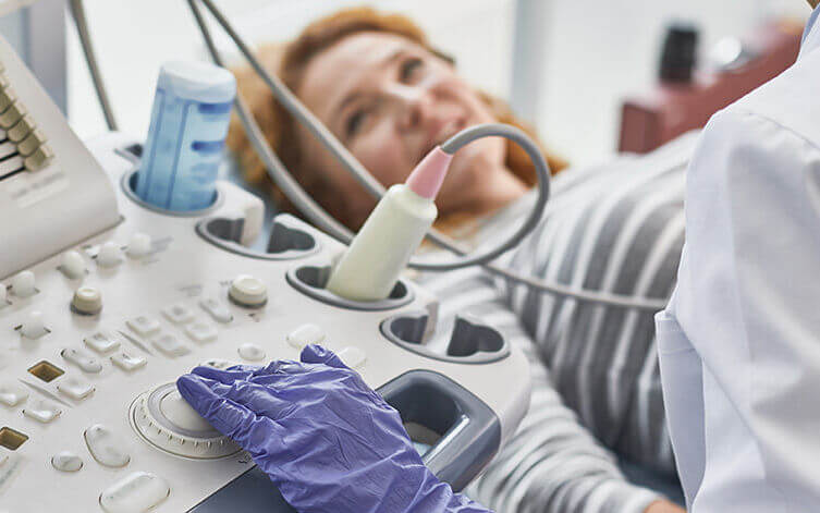 Ärztin untersucht mit dem Ultraschall eine Frau.